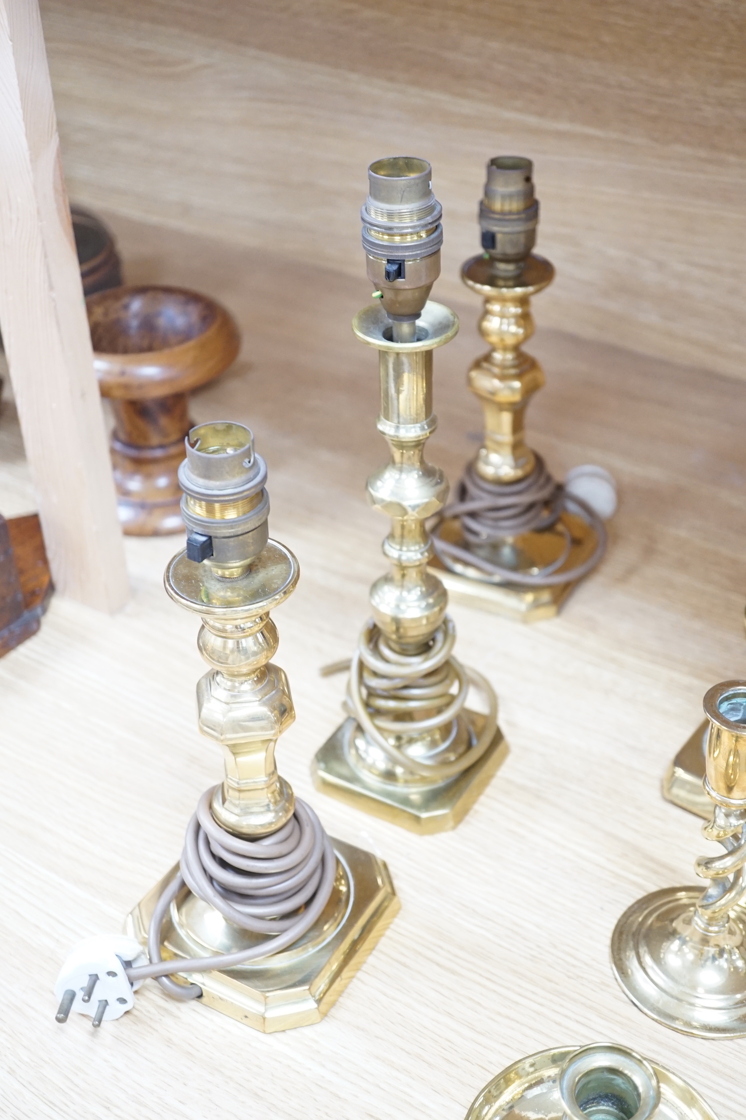 Four pairs of brass candlesticks, and another three converted to lamps, tallest 31cms high